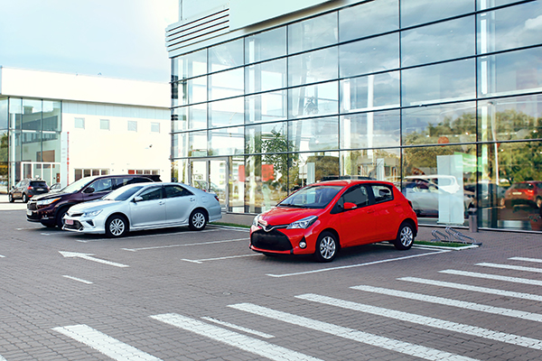 cars parked glass building dealership