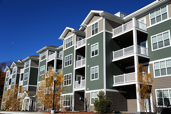 condos multistory green paint white balconies blue skies