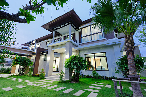 modern house green grass stepping tiles windows palm trees