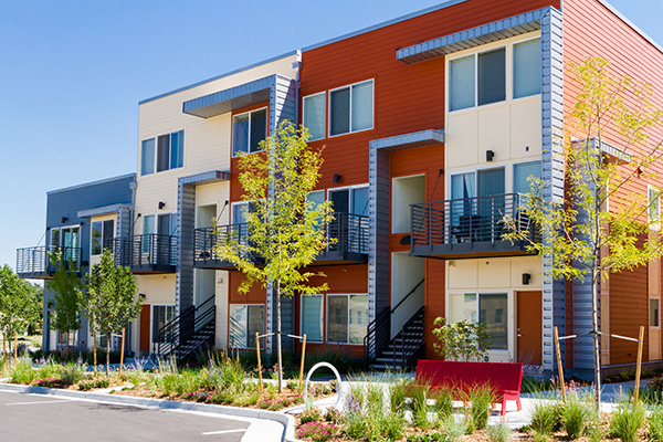 multi-family apartments different colored paint red new trees bushes